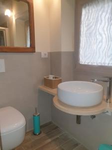 bagno con lavandino, servizi igienici e specchio di Bagni San Filippo Casa gelsomino a Bagni San Filippo