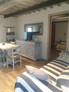 a room with two beds and a table and a television at Bagni San Filippo Casa gelsomino in Bagni San Filippo