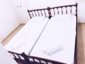 two beds in a room with white walls at Artemonahi Traditional Cosy House in Artemonas