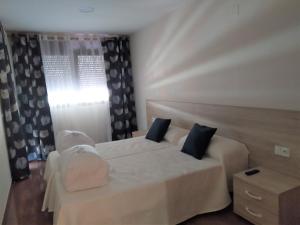 1 dormitorio con cama blanca y almohadas azules en ANCLA spaces EGVT-436-CS en Vinarós