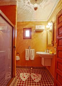 ein Badezimmer mit einem Waschbecken, einem WC und einem Spiegel in der Unterkunft Riad Dar Essalam in Marrakesch