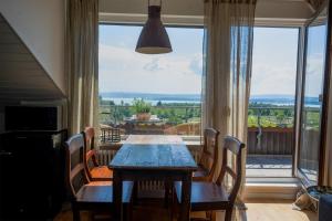 a dining room with a table and chairs and a large window at Das Nest am Wohrenberg in Daisendorf