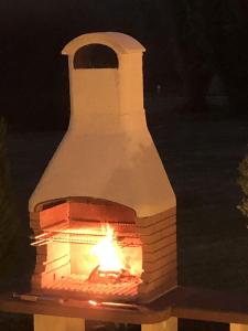 un horno de ladrillo con fuego en él por la noche en DCV Summer Home, en Blis-et-Born