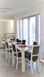 a white dining room table with chairs and laptops on it at Ludna 3 in Niechorze