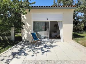 un patio con una sedia blu di fronte a una casa di Studio équipé indépendant chaleureux lumineux a Saubens