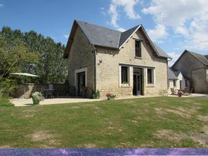 a stone house with a lawn in front of it at La linotiere in Osly-Courtil