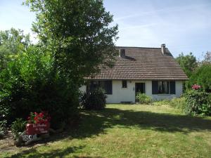 una casa blanca con un árbol y un patio en chambres du grès rouge de Beauval, en Beauval