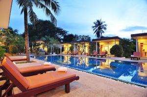 a resort pool with lounge chairs and a resort at Phuket Sea Resort SHA Extra Plus in Rawai Beach