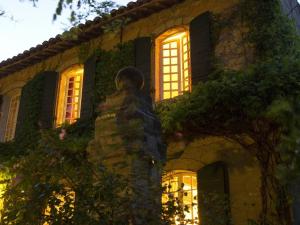 a building with windows and a statue in front of it at Domaine de Rhodes B&B in Avignon