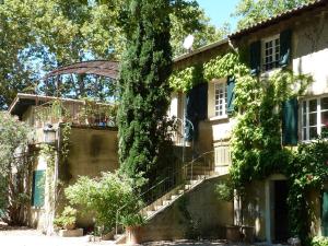 an ivy covered house with stairs and a tree at Les Gîtes du Domaine de Rhodes in Avignon