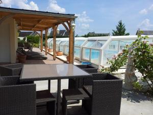 eine Terrasse mit einem Tisch, Stühlen und einem Boot in der Unterkunft Cafecouet'Breizh in Guipry-Messac