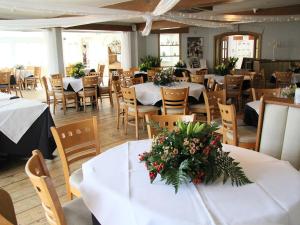 un restaurante con mesas blancas y sillas con flores. en The WatersEdge, Canal Cottages en Hillingdon
