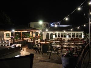 a restaurant with wooden tables and lights at night at The WatersEdge, Canal Cottages in Hillingdon