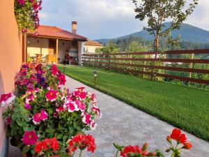 un jardín con flores rosas y una valla en Къща за гости Романс en Yagodina