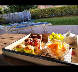 un vassoio di cibo e un cesto di frutta su un tavolo di B&B Baratoff a Pesaro