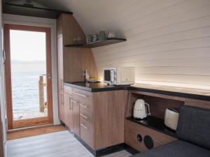 a kitchen with a counter with a microwave and a window at Door to the Shore - Seafront Cottages in Sandhaven