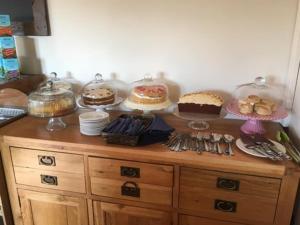 a cabinet with cakes and other desserts on top of it at Double-Gate Farm in Wells