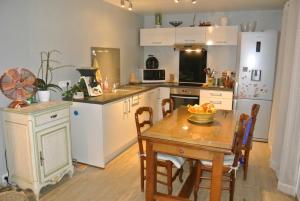 BuissonにあるGîTE du GOUR du PEYROLの木製のテーブルとダイニングルームのあるキッチン