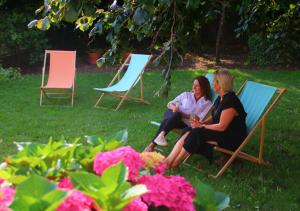 dos mujeres sentadas en sillas de césped en el césped en De Villo, en Hasselt