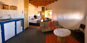 a room with a kitchen and a bedroom with a bed at Atacama Loft & Glamp in San Pedro de Atacama