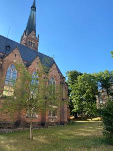 an old brick church with a tower and a tree at ZEYER APARMENTS in Teplice