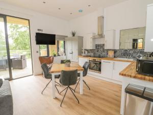 a kitchen with a table and chairs in a room at The Leat in Redditch