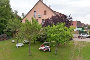 a group of people sitting on picnic tables in a yard at L'éclos des vignes - Appartements haut de gamme avec Spa in Bergheim