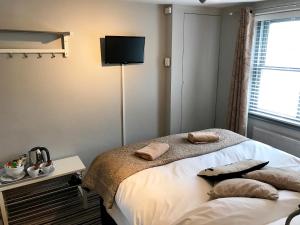 a bedroom with a bed with a flat screen tv on the wall at EI8HT Brighton Guest Accommodation in Brighton & Hove
