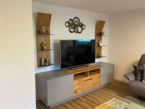 a living room with a flat screen tv on a entertainment center at Ferienwohnung Katharina 4 Sterne laut DTV Wallbox 11KW in Nideggen