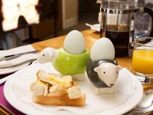 a plate of food with eggs and bread on a table at Elder Grove in Ambleside