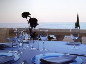 a table with wine glasses on a table with the ocean at Hotel El Dorado in Carboneras