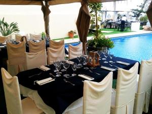 a table with wine glasses on it next to a pool at Hotel El Dorado in Carboneras