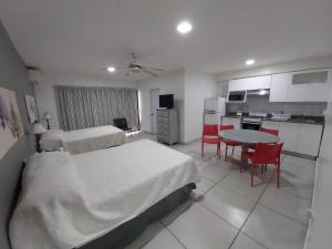 a room with two beds and a table and a kitchen at Apart Hotel Turey in Santo Domingo