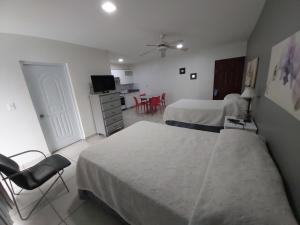 um quarto de hotel com duas camas e uma mesa e cadeiras em Apart Hotel Turey em Santo Domingo