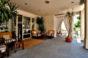 ein Wohnzimmer mit Topfpflanzen und einem Tisch in der Unterkunft Le Rose Suite Hotel in Rimini