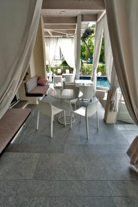 a room with a table and chairs and a pool at Le Rose Spa Hotel in Rimini
