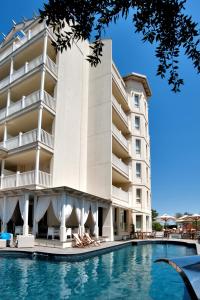 un hotel con piscina di fronte a un edificio di Le Rose Suite Hotel a Rimini