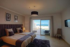 a bedroom with a bed and a sliding glass door at The Beachfront - Praia D'El Rey Golf & Beach Resort in Casal da Lagoa Seca