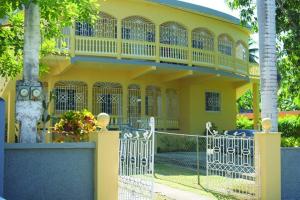 a yellow house with a gate in front of it at Unity Villa Near Montego Bay and Beaches free WiFi 2bedrooms in Montego Bay