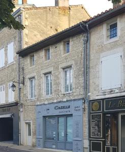 un antiguo edificio de piedra en una calle de la ciudad en Gazelle Guest House and Art Gallery, en Ruffec