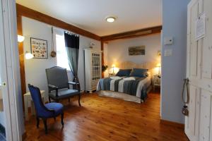 a bedroom with a bed and a desk and a chair at Escale du Nord in Mont-Tremblant