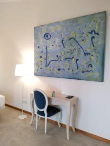 a desk with a chair and a painting on the wall at STARBAL Love in Es Castell