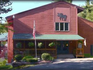 a red building with a horse sign on it at Evergreen Valley Inn in North Lovell
