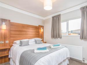 a bedroom with a large bed with two towels on it at Fab Apartment in Loughborough