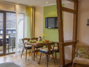 a dining room with a table and chairs and a television at Ferienweingut Stein in Valwig