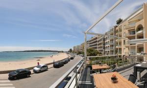 a view of the beach from the balcony of a hotel at Fettolina Palm Beach, Location Cannes front de mer et plage in Cannes