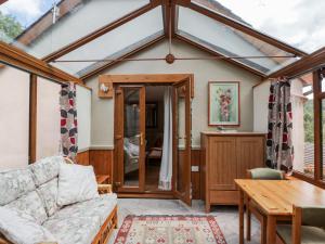 a conservatory with a couch and a table at Calcott Annexe in Ross on Wye