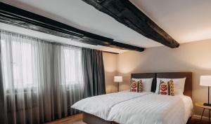 a bedroom with a bed and a large window at Hotel zum Heidkrug & Café Lil in Lüneburg
