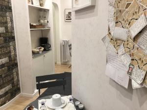 una sala da pranzo con tavolo e parete con poster di LE FATE SUITES a Roma