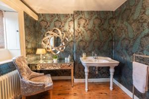 uma casa de banho com um lavatório e uma cadeira em Florence Nightingale Suites at Lea Hurst em Highpeak Junction